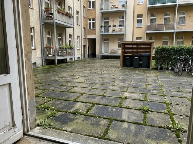 Innenhof einer Wohnanlage, Pflaster dunkel und vermoost